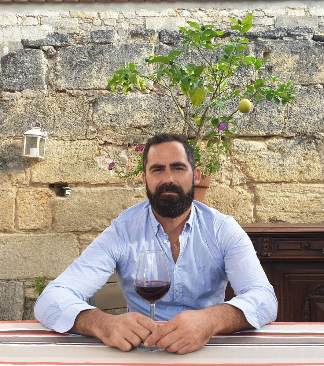 Cédric Dublaix, vigneron du Château Dedieu, devant un verre de vin rouge